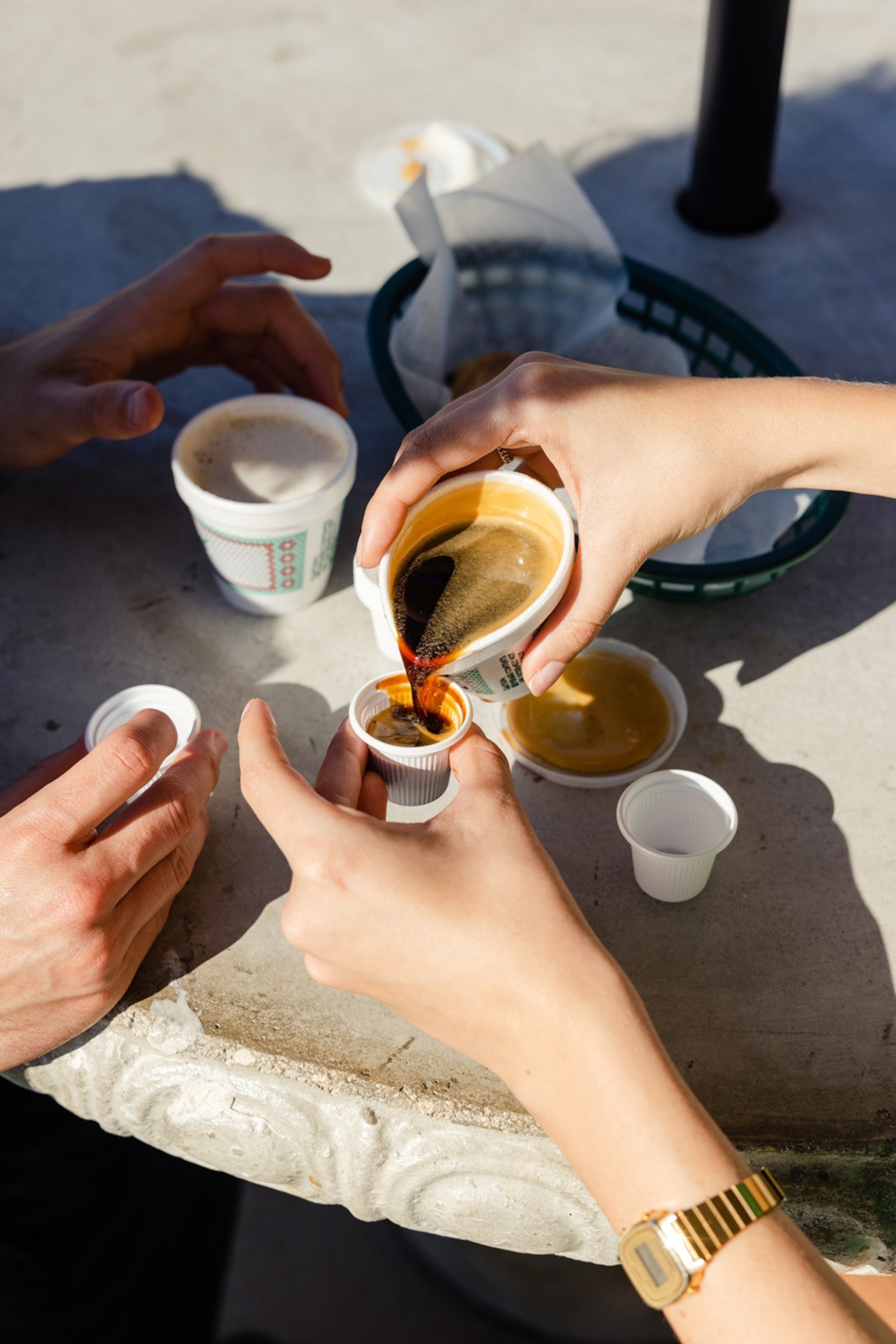 People pouring coffee from cups into espresso pots