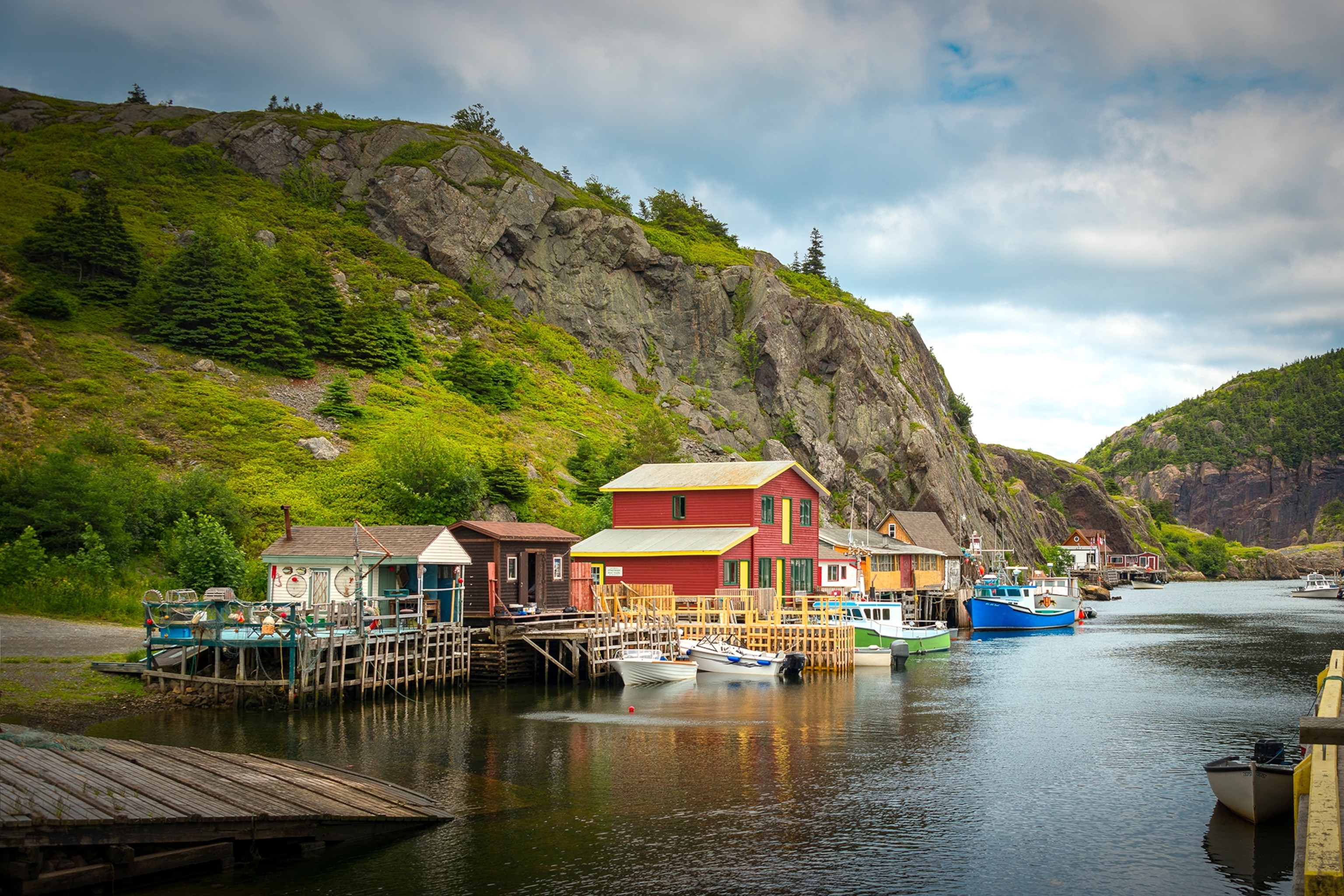 Wooden huts and houses perched on a river surrounded by mountains