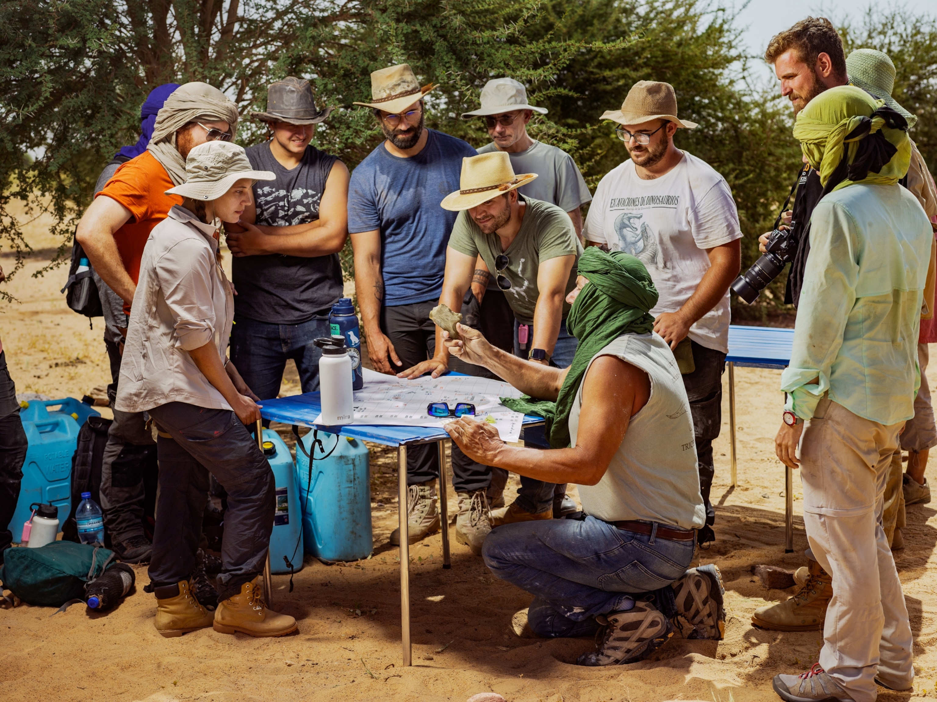 people standing around a table looking at fossils and bones